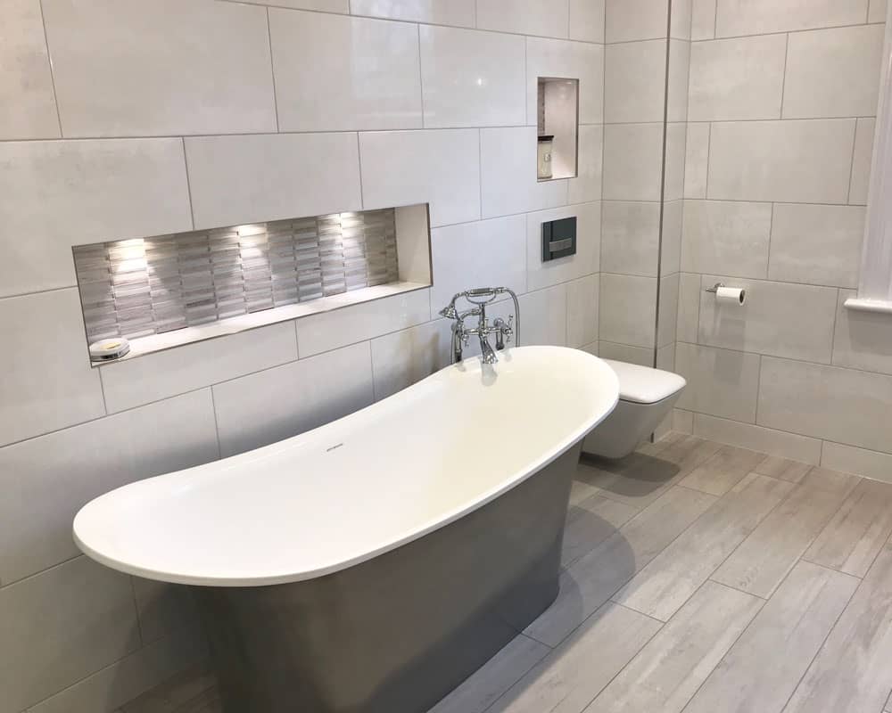 Dark grey freestanding bath with white tiles