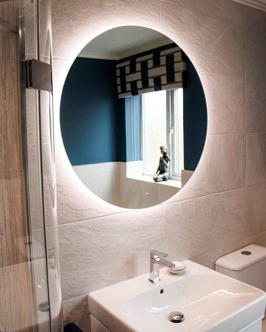 Circular light up mirror and white sink